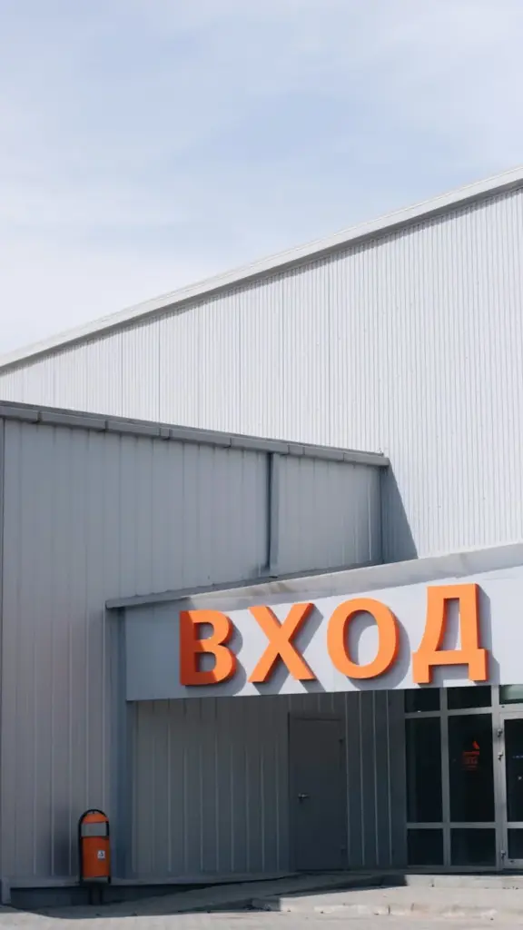 Modern warehouse entrance featuring bold signage under clear skies, perfect for industrial themes.