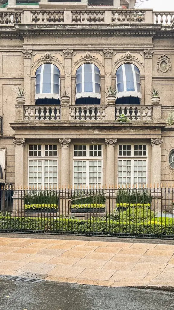 A detailed view of a historic stone building facade with balconies and decorative windows.