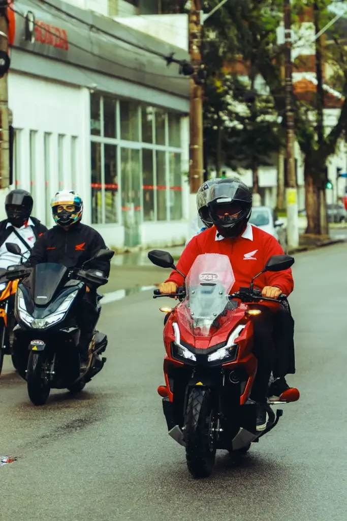 A group of motorcyclists on Honda motorcycles riding through the streets of Santos, Brazil.