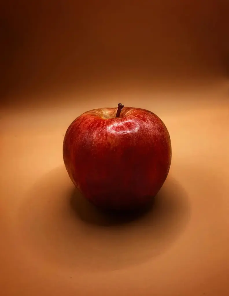 A vibrant red apple set against an earthy background, ideal for stock photo use.