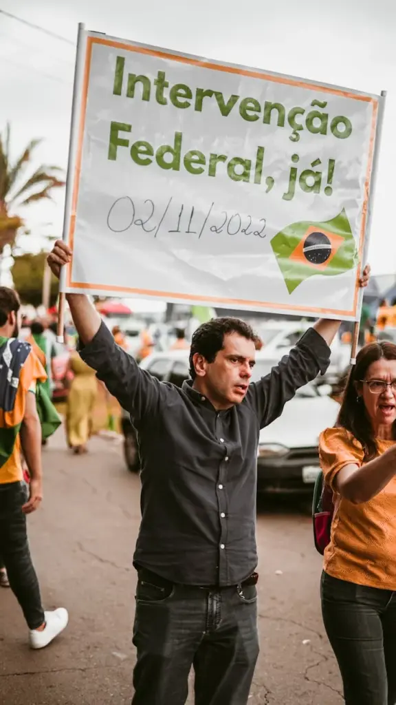 Man holding a protest sign during a peaceful demonstration in Brazil.
