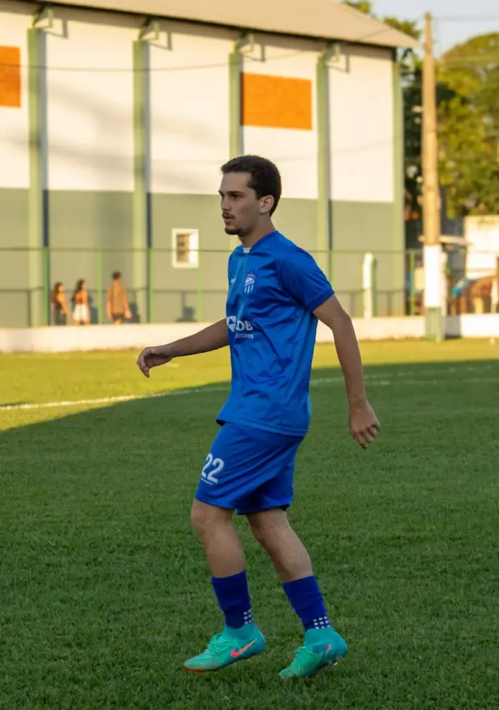 A soccer player wearing a blue uniform running during a match on a green field.