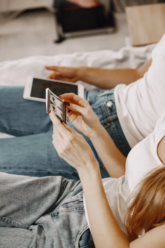 A couple sits at home holding an ultrasound scan, symbolizing family planning and parenthood.