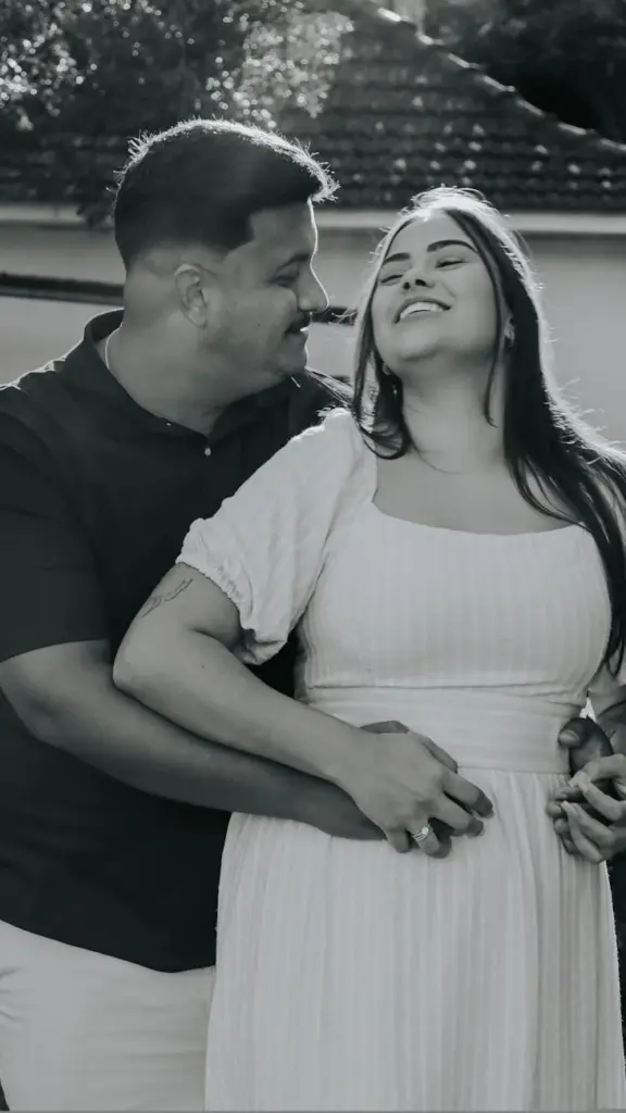 Happy couple embracing outdoors, captured in a warm moment of affection.