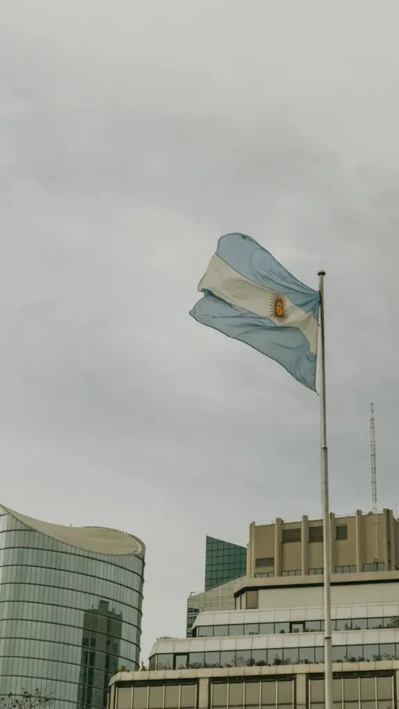 Argentinian flag flying high amidst the modern skyline of Buenos Aires, capturing national pride.