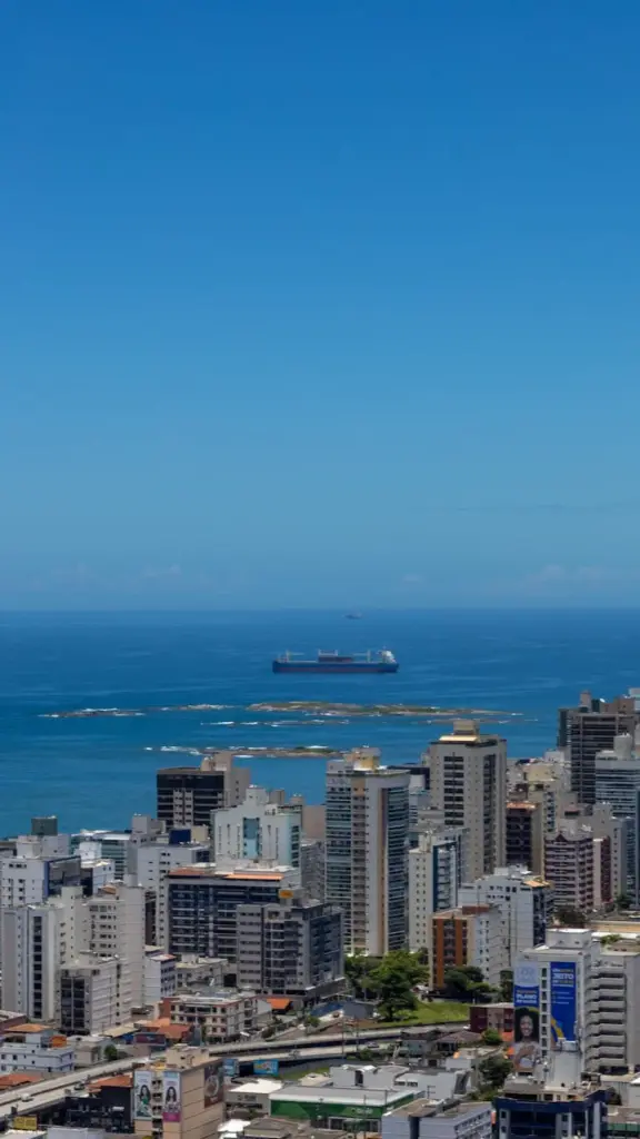 Stunning skyline view of Vila Velha, Brazil, with a distant ocean horizon and shipping vessel.