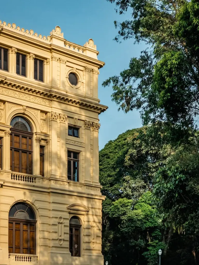 Elegant historic building facade surrounded by lush greenery in São Paulo, Brazil.