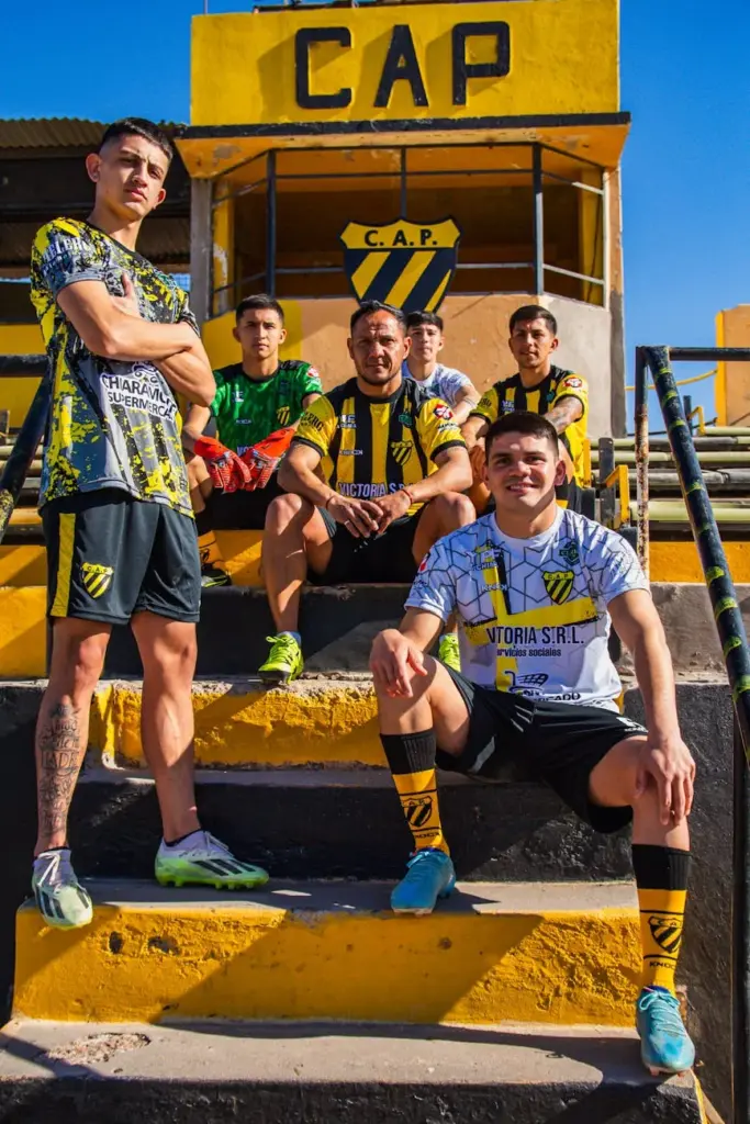 Soccer team members pose on stadium steps in sportswear. Vibrant and energetic outdoor group shot.