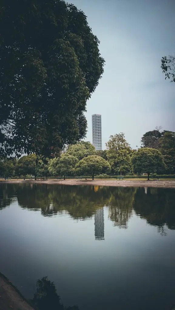 Serene view of a park pond with a tower reflecting in Kolkata, India.