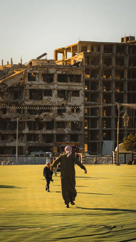 Father and child playing near a war-torn building, symbolizing hope and resilience.