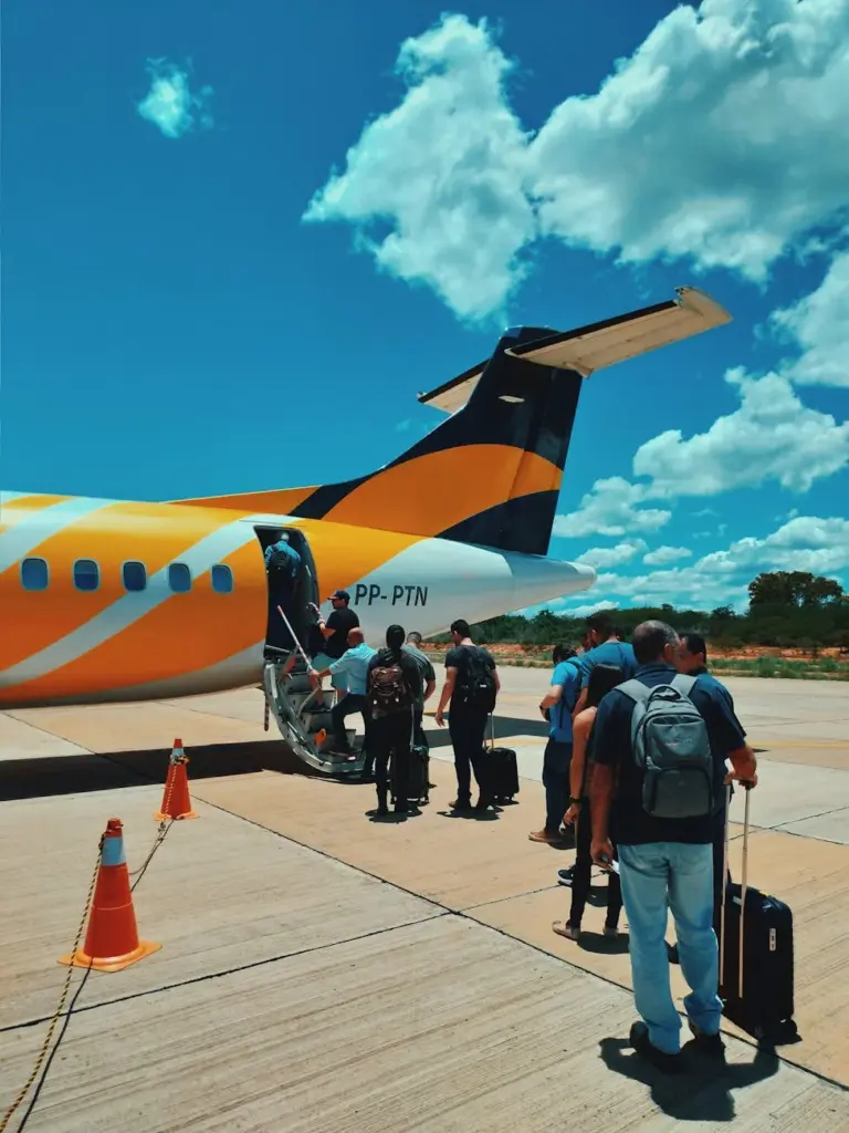 Back view of passengers keeping social distance while boarding on plane during coronavirus pandemic