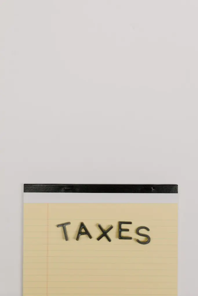Notepad with the word 'Taxes' on a white background, ideal for finance themes.
