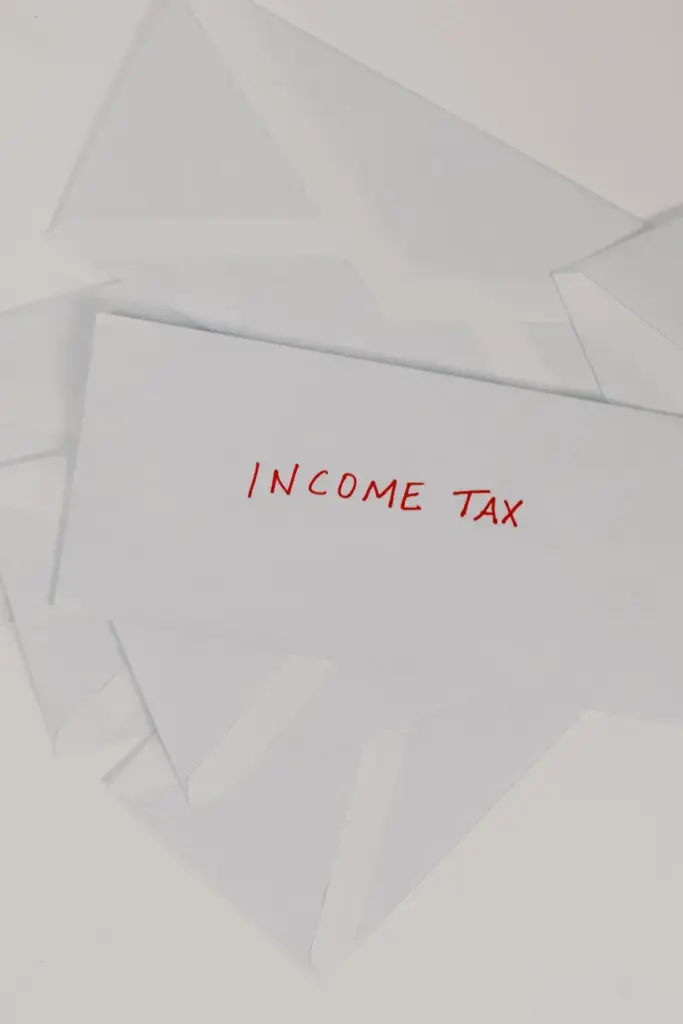 Top-down view of an envelope labeled 'Income Tax' on a white background, representing finance and taxation.
