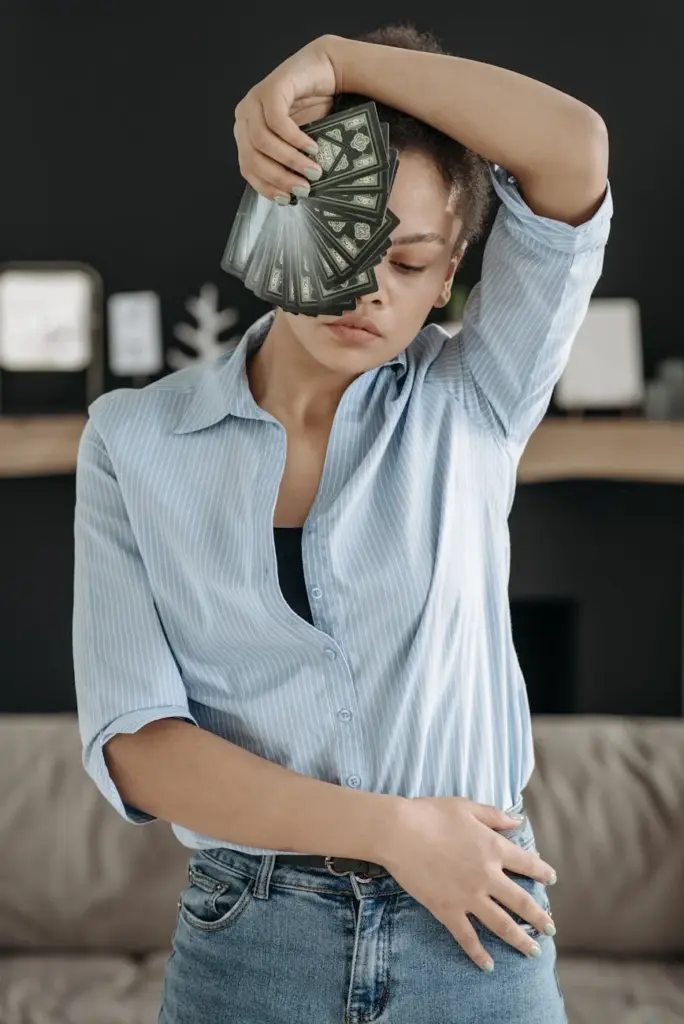 A stylish woman in a blue shirt striking a pose while holding banknotes, creating a fashion-forward look.