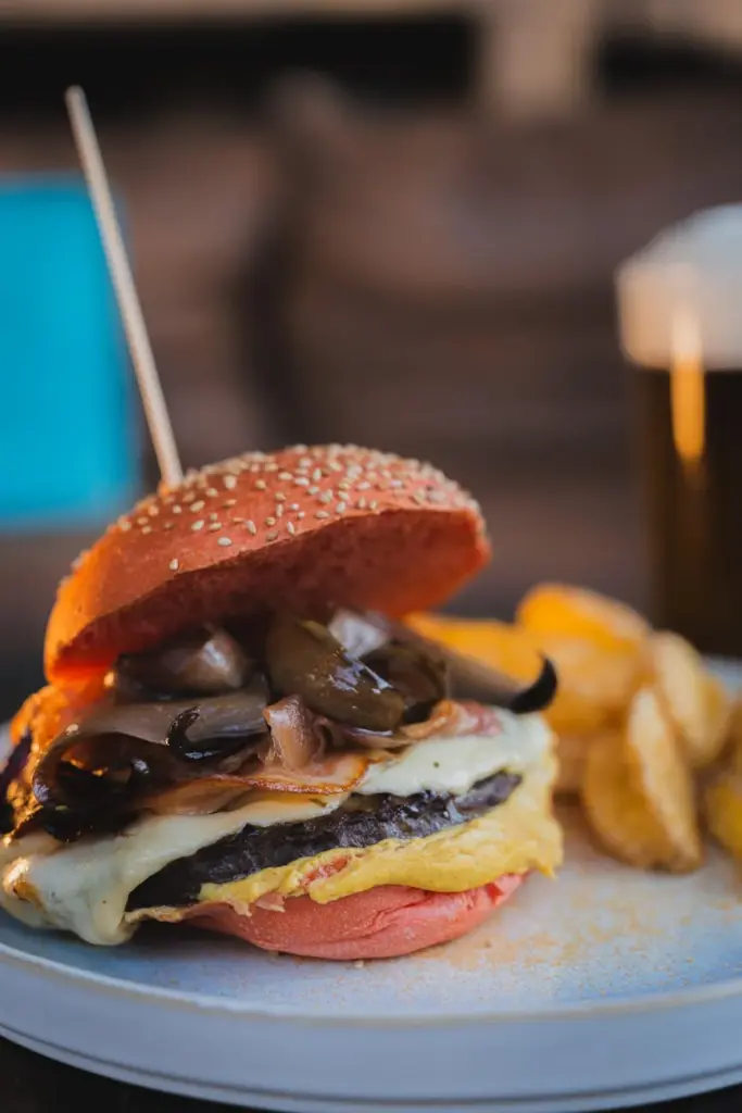 Delicious gourmet burger topped with melted cheese and mushrooms, served with crispy fries.