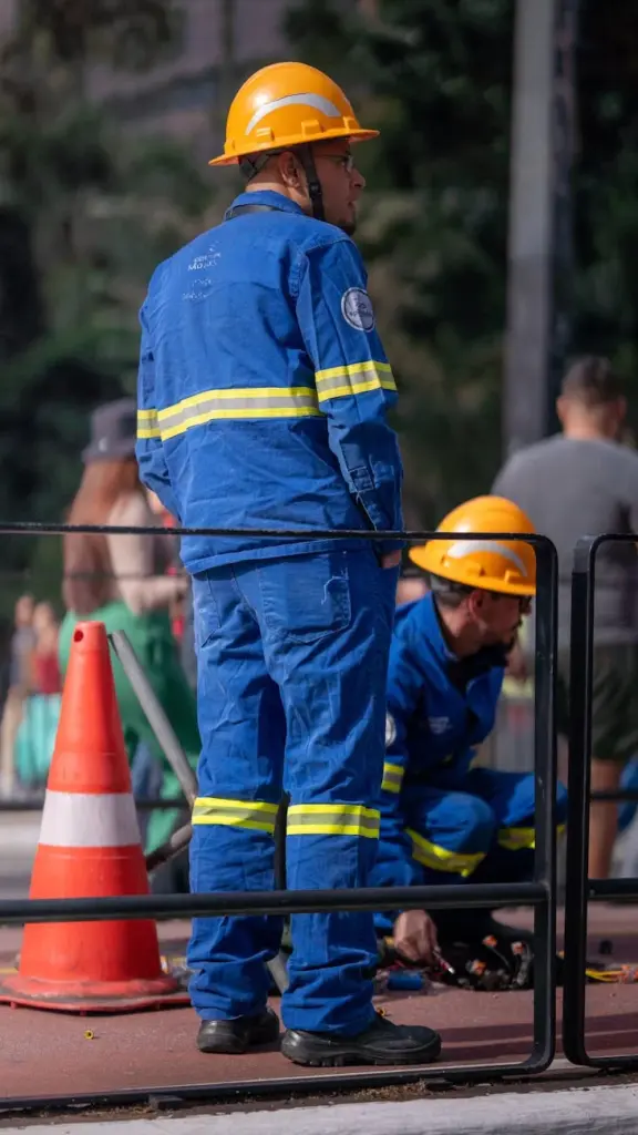 Workers in protective gear at a construction site ensuring safety and teamwork.