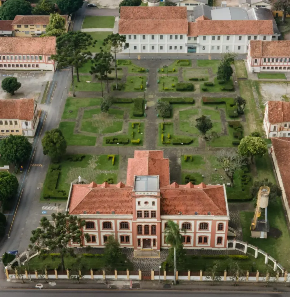 Aerial shot of a historical building and garden in Curitiba, highlighting classic architecture and cityscape.