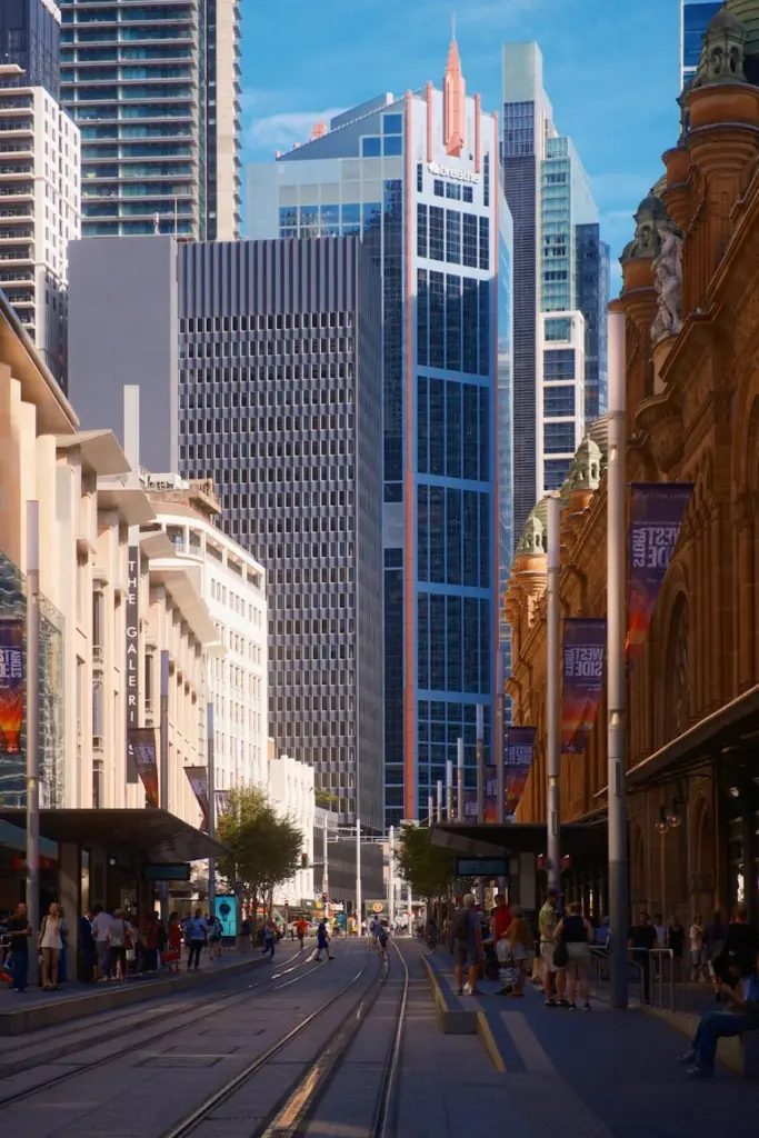 Dynamic urban scene featuring Sydney's bustling street and modern skyscrapers on a sunny day.