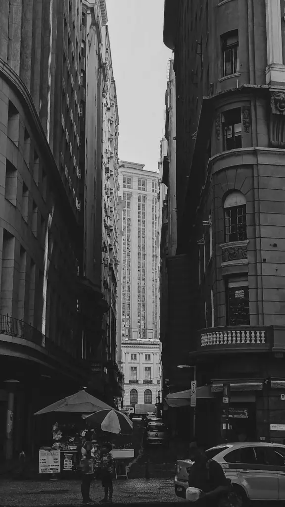 Dramatic black and white photo of a downtown cityscape with buildings and street.