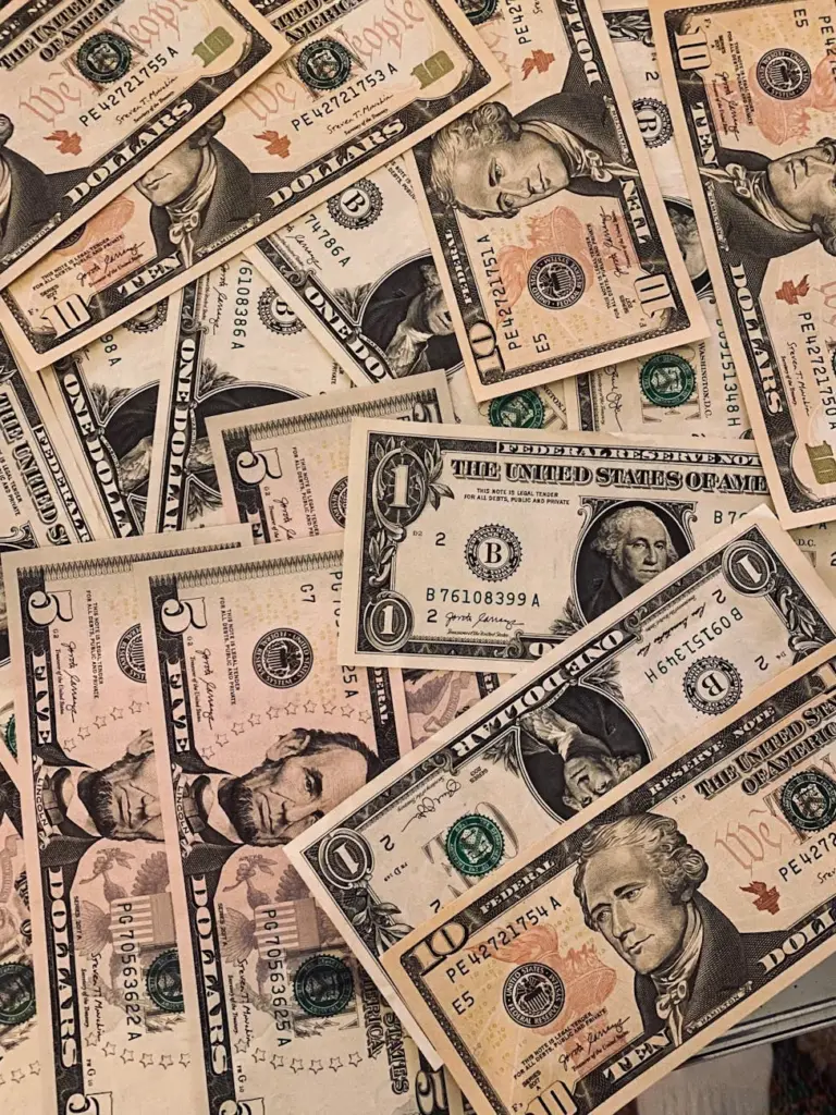 A collection of various US dollar banknotes arranged in an overlapping pattern.