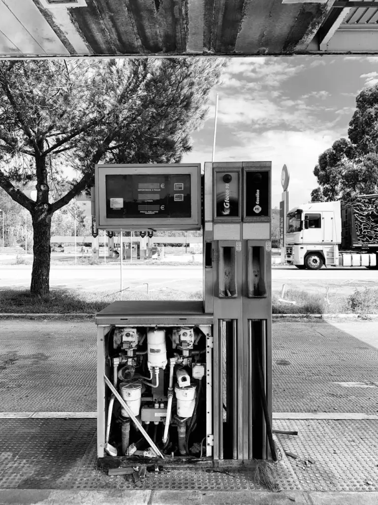 Black and white image of an old fuel dispenser at an empty gas station in Portugal.