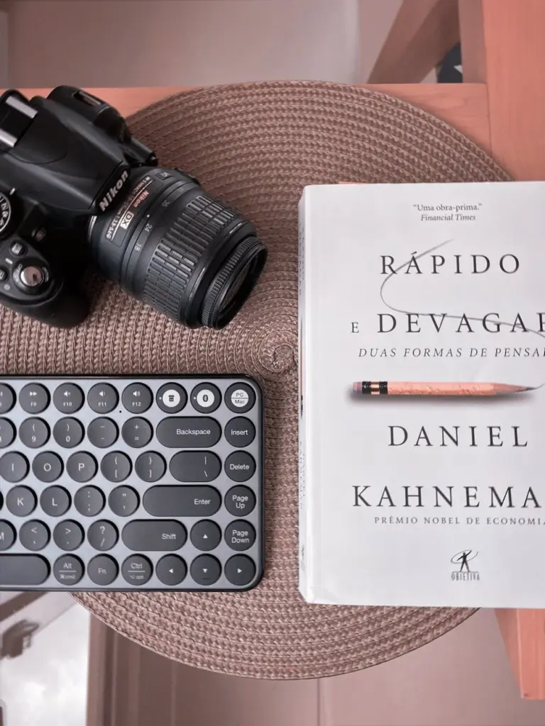 Flat lay of camera, book, and keyboard on a placemat for lifestyle inspiration.