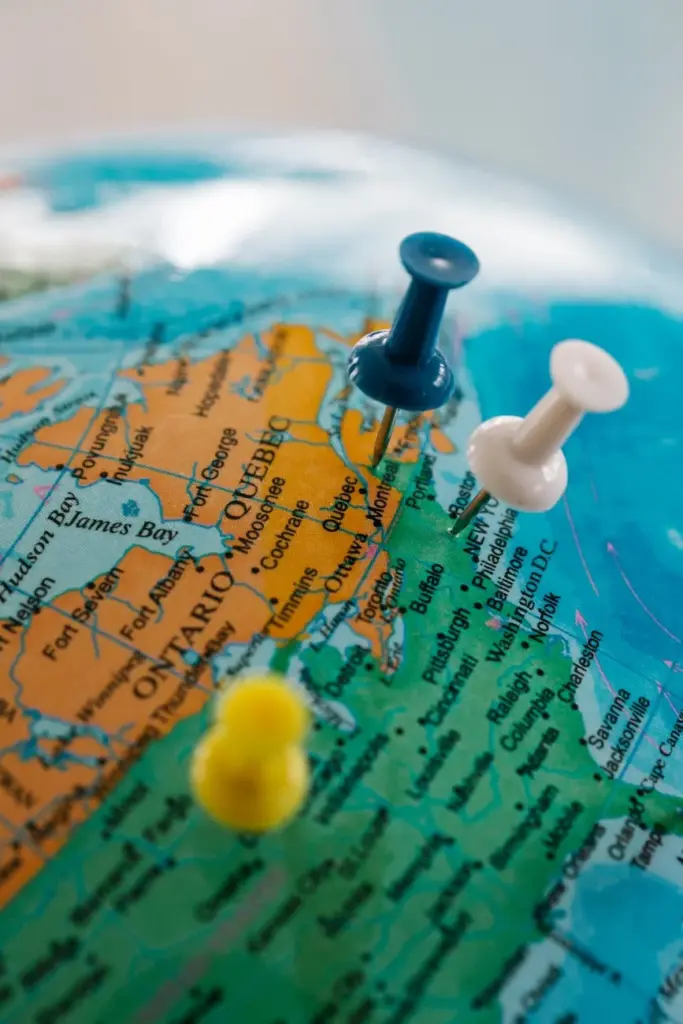 Detailed view of a globe with blue, white, and yellow pushpins marking locations.