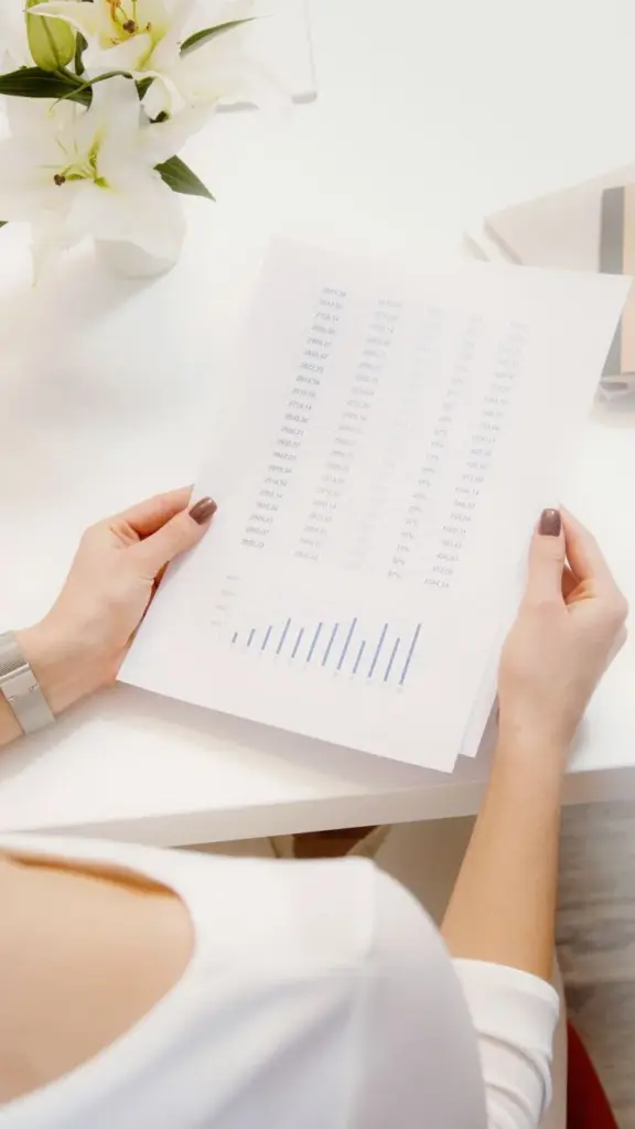 An overhead view of a person reviewing financial documents with graphs.