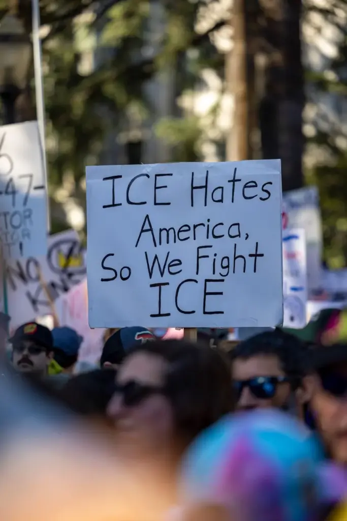 Protest scene with people holding signs in Sacramento, California advocating against ICE.