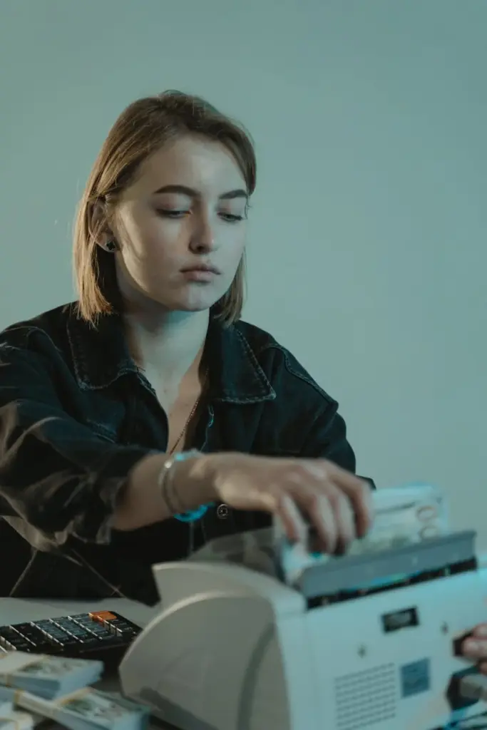 Young woman using a cash counting machine while working indoors.