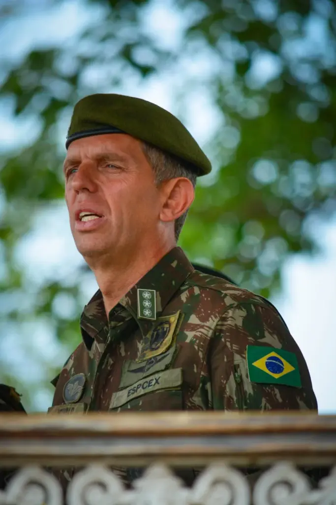 A Brazilian military officer in uniform with camouflage and national flag patch.