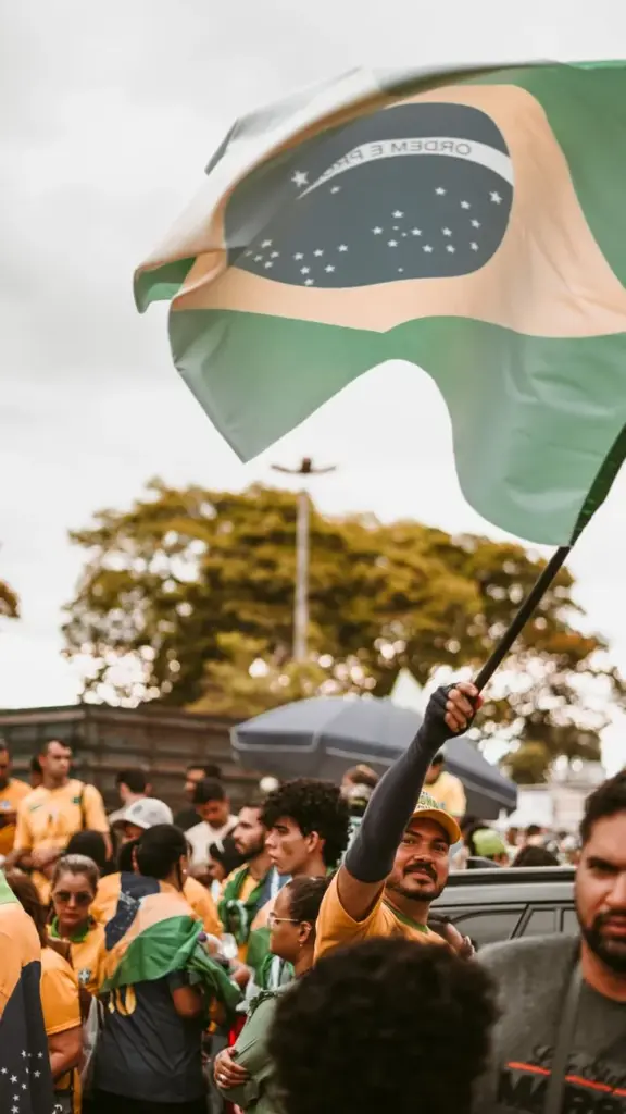 Crowd holding a Brazilian flag at a peaceful street rally.