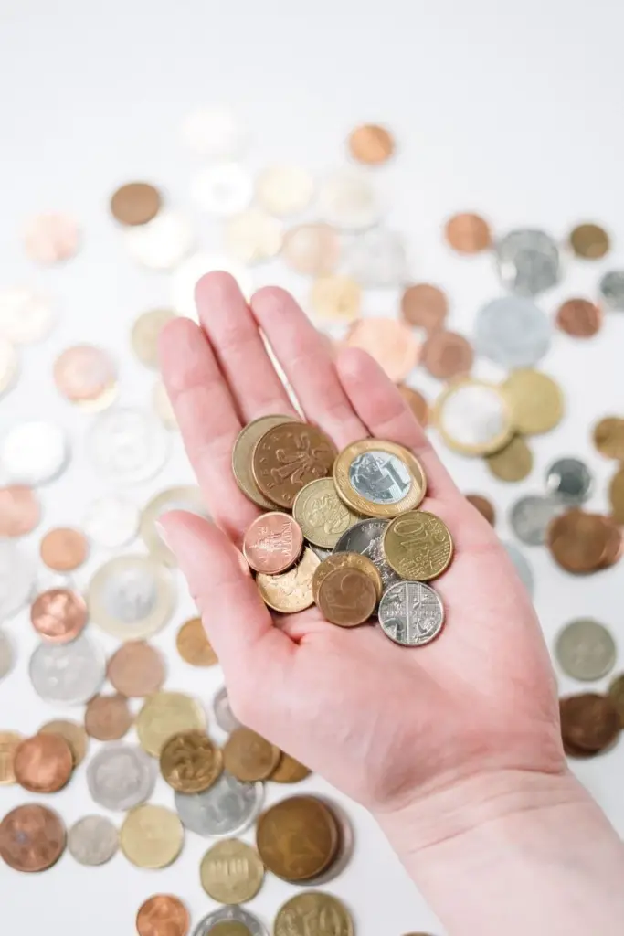 Close-up of a hand holding diverse coins, symbolizing global currency and finance.