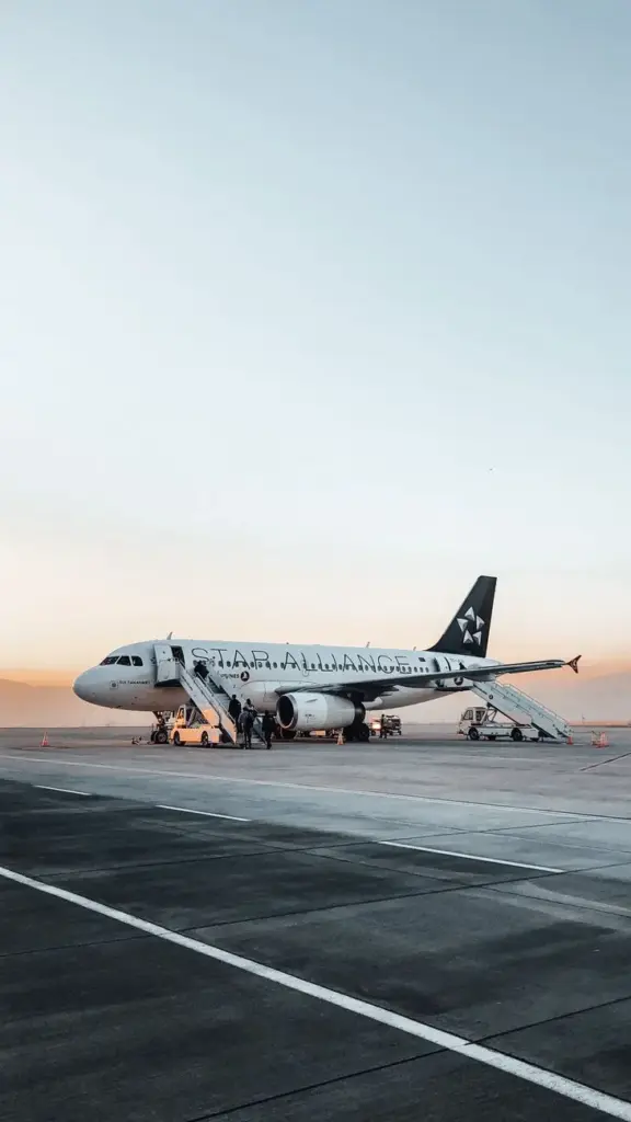 Airplane with opened doors and stairs places on empty asphalt road near  airport