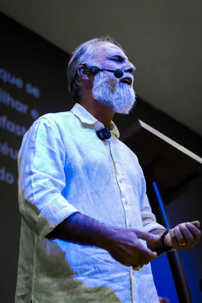 Man delivering an engaging presentation on stage with a microphone.