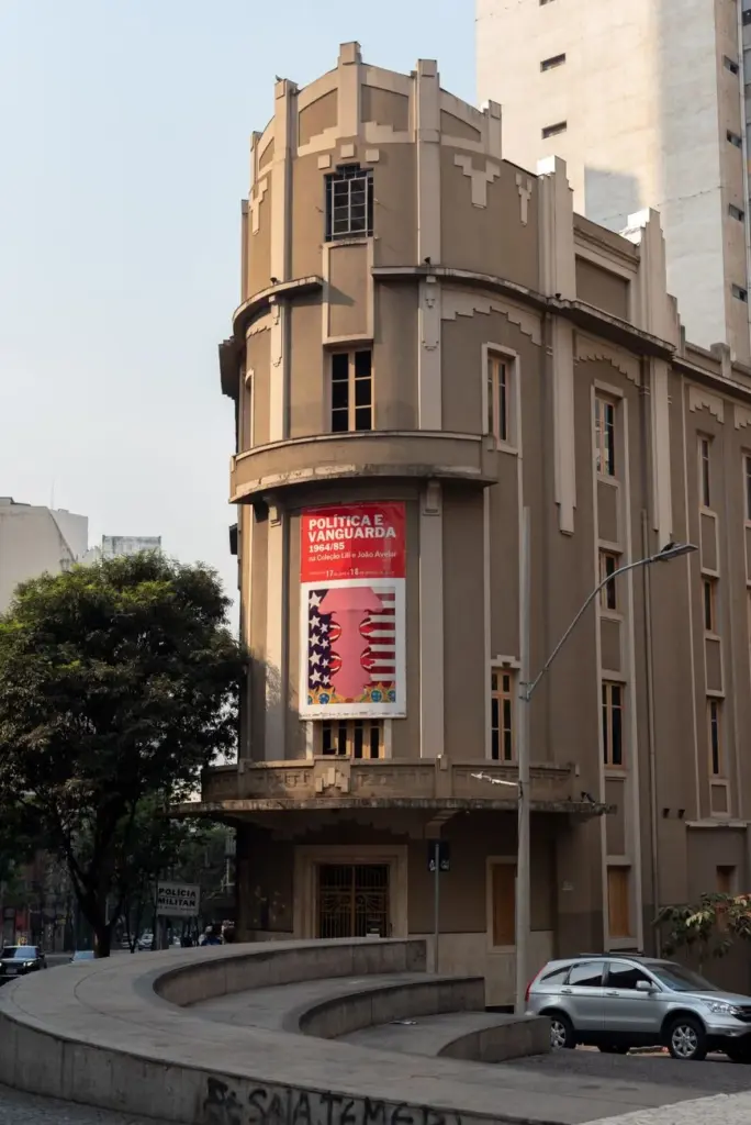 View of a historic building in Belo Horizonte with a prominent art exhibition poster.