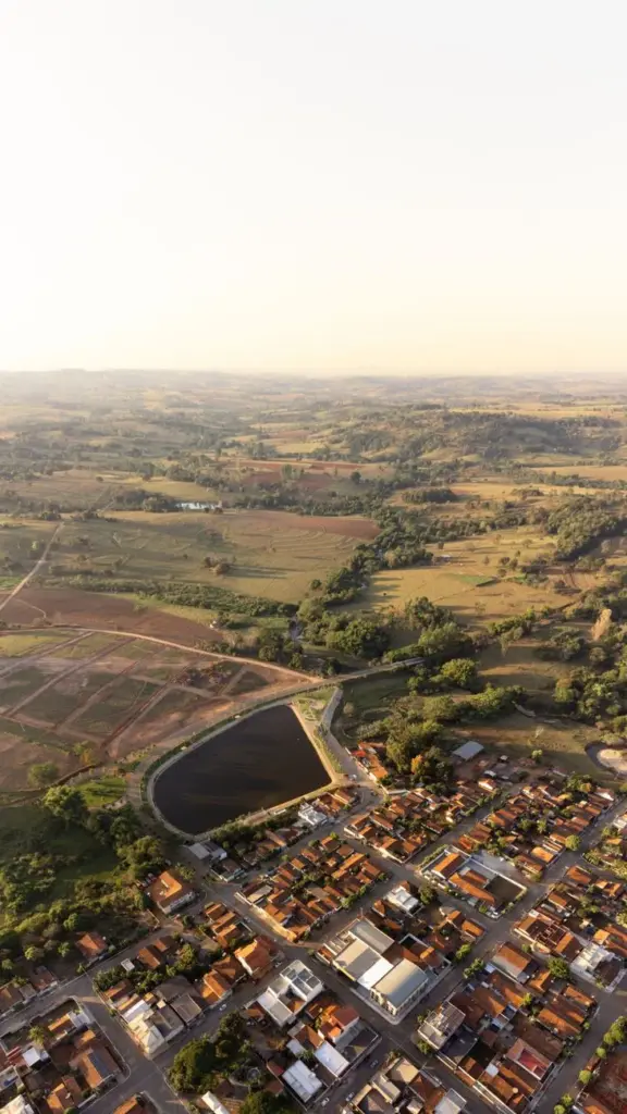 Drone shot capturing farmland and townscape in Guaraíta, Brazil at dusk.