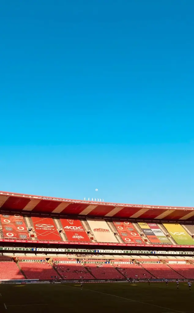 Vibrant sports stadium view with clear sky, showcasing architecture and event atmosphere.