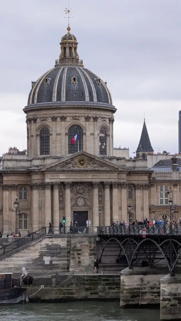View of the Institut de France with the Pont des Arts in Paris, bathed in a cloudy atmosphere.