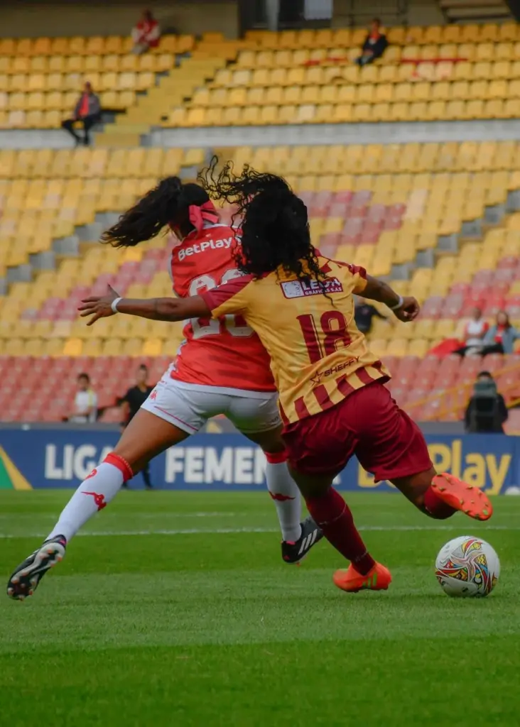 Intense women's soccer match action on the field with two competing players.