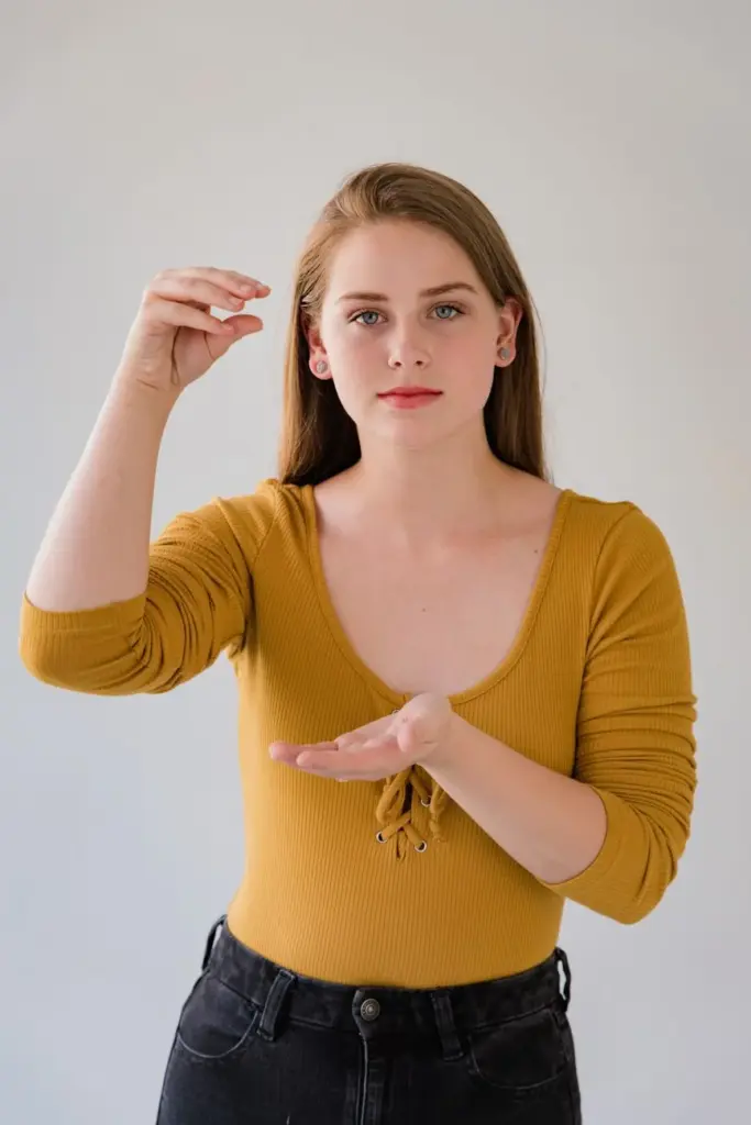 Young woman in casual attire using sign language for communication.