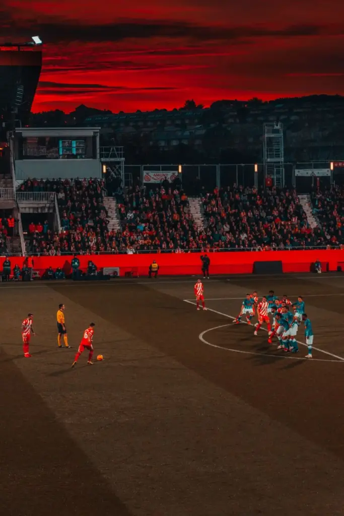 Exciting soccer match with teams in vibrant uniforms competing at sunset.