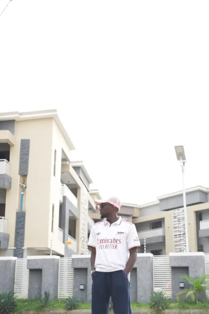 Casual portrait of a young man in front of modern architecture in Abuja, Nigeria.