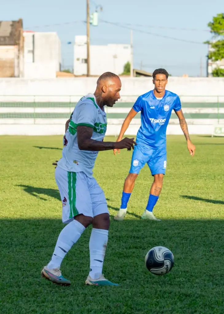 Two male soccer players in action on a sunny day during a competitive match.