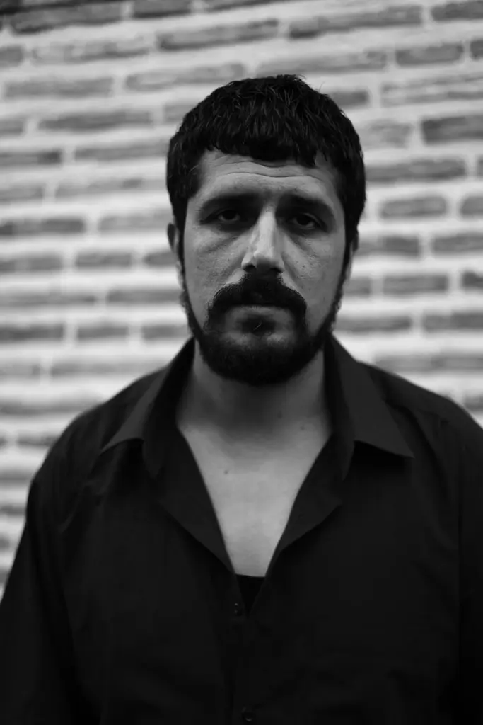 A contemplative black and white portrait of a man in Türkiye, captured outdoors.