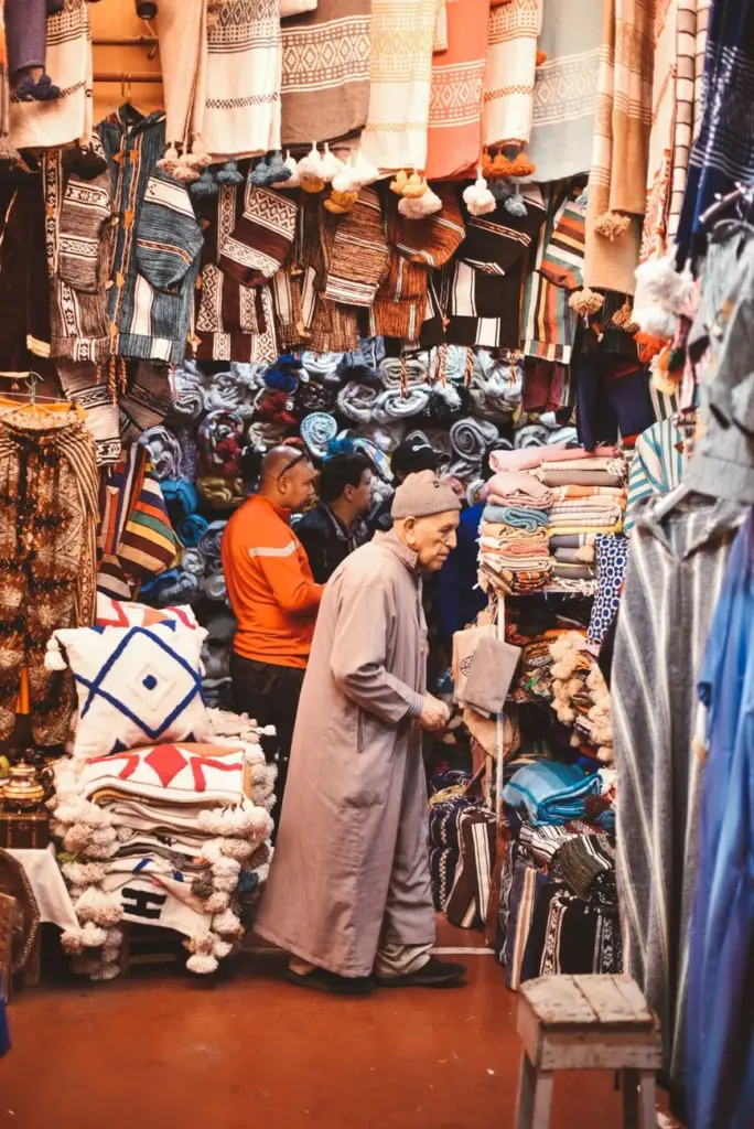 Explore the vibrant textiles and traditional garments in Agadir's lively market.