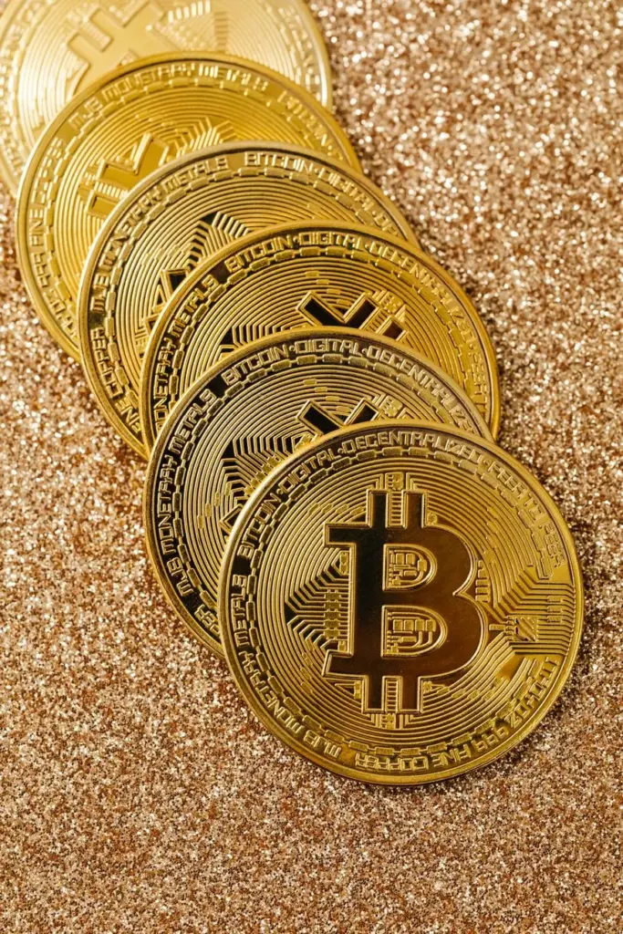 Golden Bitcoin cryptocurrency coins stacked on a glittering surface representing digital wealth and blockchain.