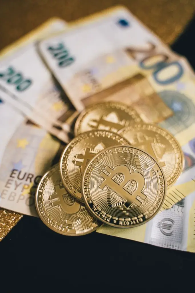Close-up of golden bitcoins placed on Euro banknotes, symbolizing cryptocurrency and finance in Berlin.