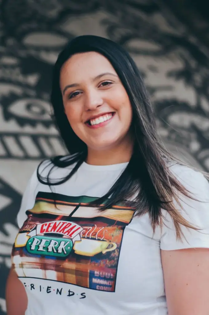 Cheerful woman posing in a Central Perk T-shirt. Outdoors, vibrant and natural portrait.
